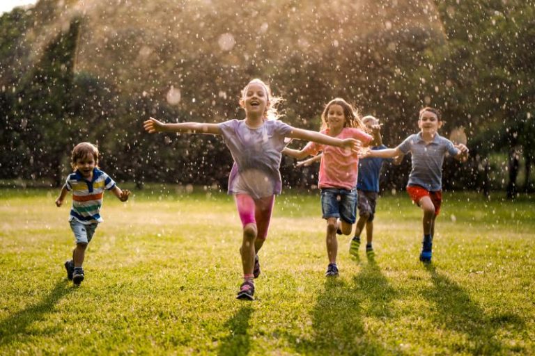Kids running together playing at the backyard