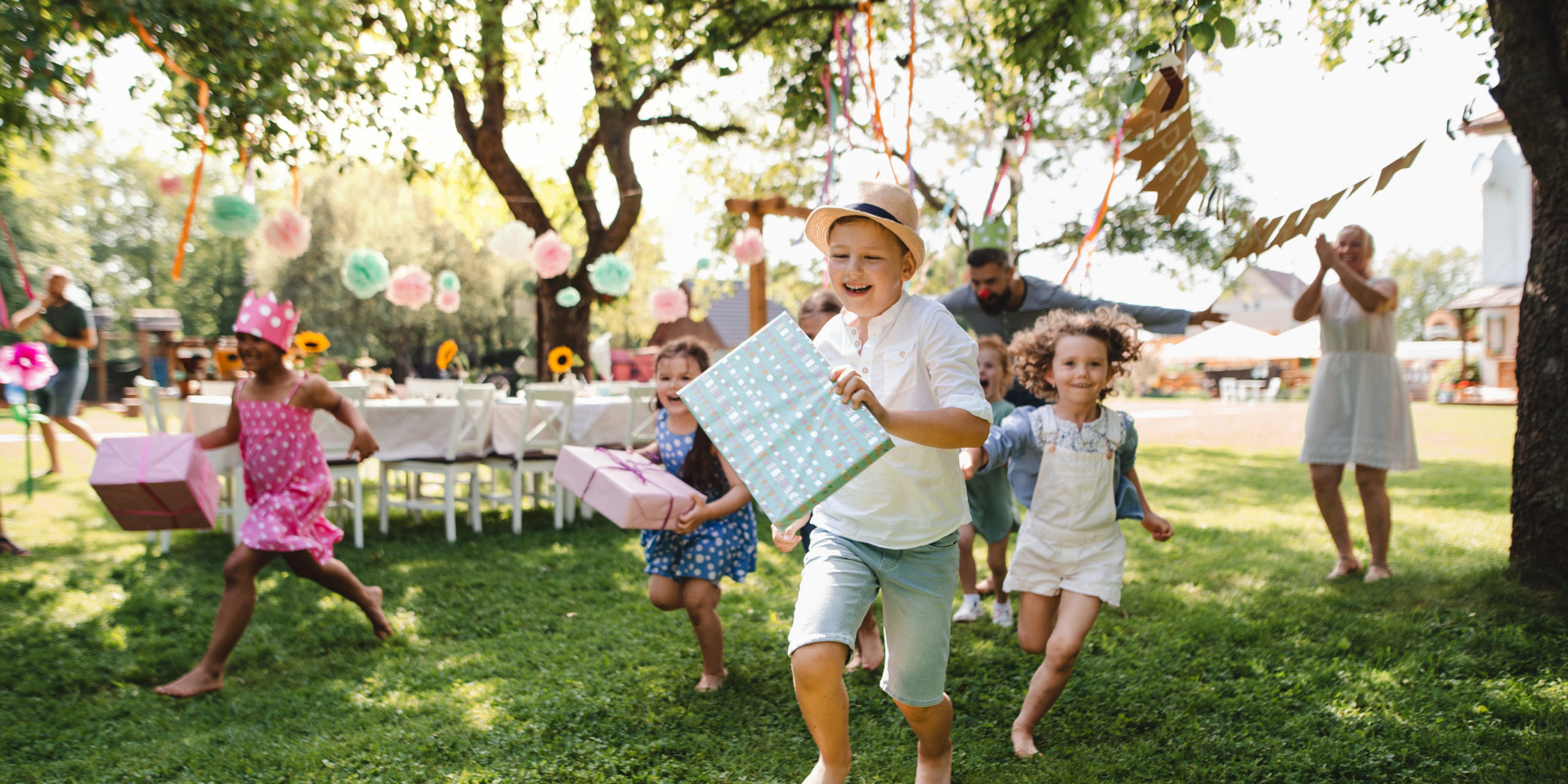 Small,Children,Ruunning,With,Present,Outdoors,In,Garden,On,Birthday